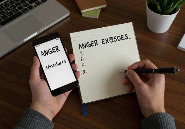 Person logging anger outbursts in a notebook or phone